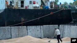 FILE - Workers load grain at a grain port in Izmail, Ukraine. Taken April 26, 2023. 