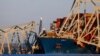 Cranes stand by as the wreckage of the Francis Scott Key Bridge rests on the container ship Dali in Baltimore, Maryland, March 30, 2024, in Baltimore.