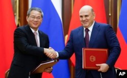 Chinese Premier Li Qiang and Russian Prime Minister Mikhail Mishustin shake hands during a signing ceremony following the 29th regular meeting between Chinese and Russian heads of government in Moscow, Russia, Aug. 21, 2024.