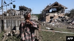 A local resident stands next to a destroyed residential house following a missile strike in Kyiv region, on Aug. 27, 2023. 