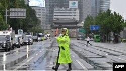 Seorang polisi mengontrol lalu lintas di jalan yang sepi selama latihan pertahanan sipil melawan kemungkinan serangan artileri Korea Utara di Seoul, 23 Agustus 2023. (Jung Yeon-je/AFP)