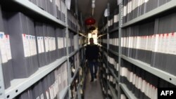 An employee walks between shelves at the archives department of the Tele Liban network in Beirut, Lebanon, Dec. 29, 2023.