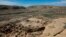 FILE - A hiker sits on a ledge above Pueblo Bonito, the largest archeological site at the Chaco Culture National Historical Park, in northwestern New Mexico, Aug. 28, 2021. 