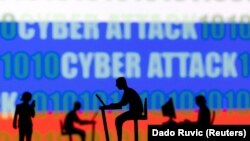 (FILE) Figures in front of the words "Cyber Attack", binary code and the Russian flag.
