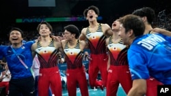 Members of Team Japan celebrate after winning the gold medal during the men's artistic gymnastics team finals round at Bercy Arena at the 2024 Summer Olympics, July 29, 2024, in Paris. 