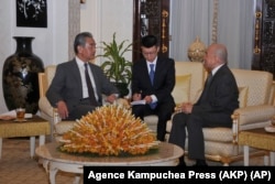 In this photo released by Agence Kampuchea Press (AKP), Chinese Foreign Minister Wang Yi, left, is welcome meeting by Cambodia's King Norodom Sihamoni, right, in Royal Palace, in Phnom Penh, April 21, 2024.