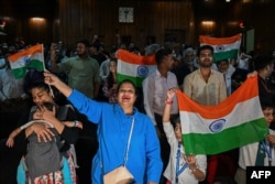 FILE - People wave India's national flag at the Nehru Science Centre in Mumbai on August 23, 2023, to celebrate the successful lunar landing of Chandrayaan-3 spacecraft on the south pole of the Moon. (Photo by Punit PARANJPE / AFP)