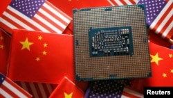 ILUSTRASI - Sebuah chip semikonduktor unit pemrosesan pusat (CPU) ditampilkan di antara bendera China dan Amerika, 17 Februari 2023. (Florence Lo/REUTERS)