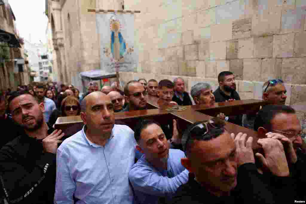 Los fieles llevan una cruz mientras participan en la procesión del Viernes Santo en la Vía Dolorosa en la Ciudad Vieja de Jerusalén.