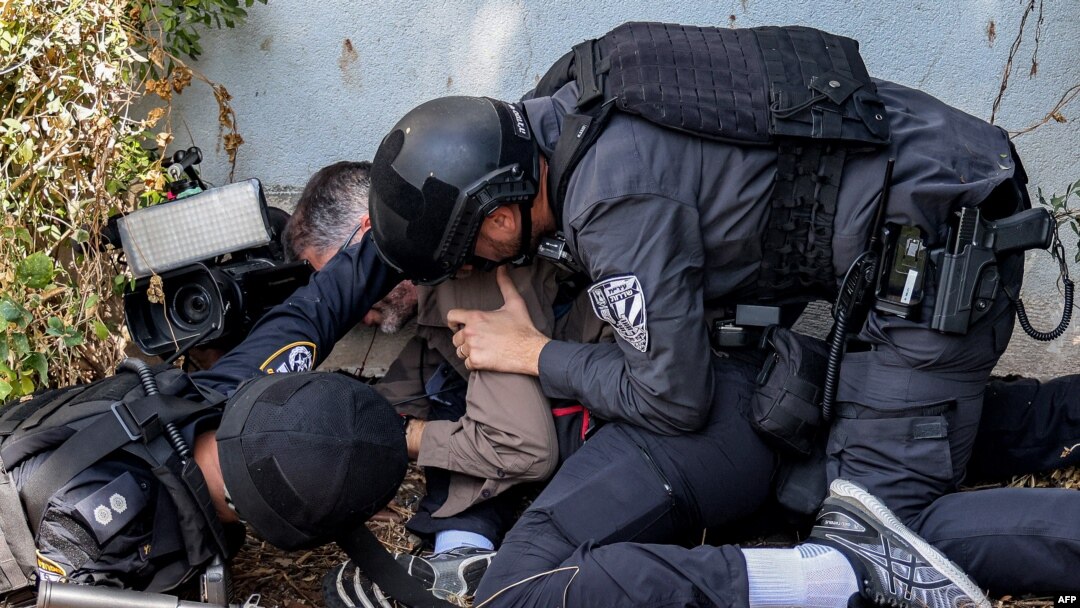 FILE — Israeli police and security forces assist a journalist taking cover during a rocket attack alert in Israel's southern city of Sderot near the border with Gaza, Oct. 12, 2023. At least 39 journalists have died while covering the Israel-Hamas war.