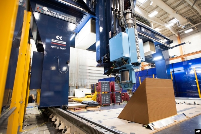 A section of wall of a house is being printed on a 3D printer at the University of Maine on Oct. 12, 2023, in Orono, Maine. An even larger printer unveiled on Tuesday, April 23, 2024, may one day create entire neighborhoods. (AP Photo/Kevin Bennett)