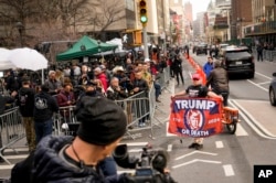 A supporter of former President Donald Trump is seen in front of assembled media and onlookers outside Manhattan Criminal Court, in New York, April 4, 2023.