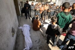 Palestinians mourn near bodies at Kamal Edwan Hospital in Beit Lahia, in the northern Gaza Strip, on Feb. 29, 2024, after Israeli soldiers allegedly opened fire at Gaza residents who rushed towards trucks loaded with humanitarian aid .