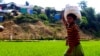 A Rohingya boy carries food rations for his family from a World Food Program-run shop in a refugee camp, Cox’s Bazar, Bangladesh, June 12, 2022.