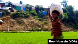 A Rohingya boy carries food rations for his family from a World Food Program-run shop in a refugee camp, Cox’s Bazar, Bangladesh, June 12, 2022.