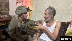 Qaid Farhan Alkadi, a Bedouin Israeli hostage kidnapped during the October 7 attack, speaks with an Israeli soldier as he is rescued at an unknown location, in this image obtained by Reuters on Aug. 27, 2024. (Israel Defense Forces/Handout via Reuters)