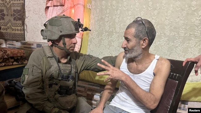 Qaid Farhan Alkadi, a Bedouin Israeli hostage kidnapped during the October 7 attack, speaks with an Israeli soldier as he is rescued at an unknown location, in this image obtained by Reuters on Aug. 27, 2024. (Israel Defense Forces/Handout via Reuters)