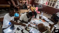 Vérification des bulletins de vote dans un bureau de vote à Kinshasa, en République démocratique du Congo, le 21 décembre 2023.