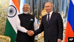 Russian President Vladimir Putin, right, and Indian Prime Minister Narendra Modi shake hands during a meeting at the Kremlin in Moscow, July 9, 2024.