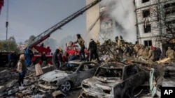 Petugas tanggap darurat Ukraina bekerja di sebuah gedung permukiman yang hancur pasca serangan Rusia di kota Uman, Ukraina tengah, 28 April 2023. 
