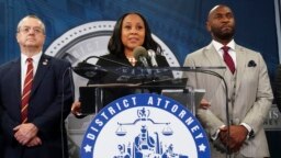 Fulton County District Attorney Fani Willis, center, speaks at the Fulton County Government Center during a news conference, in Atlanta, Georgia, Aug. 14, 2023.