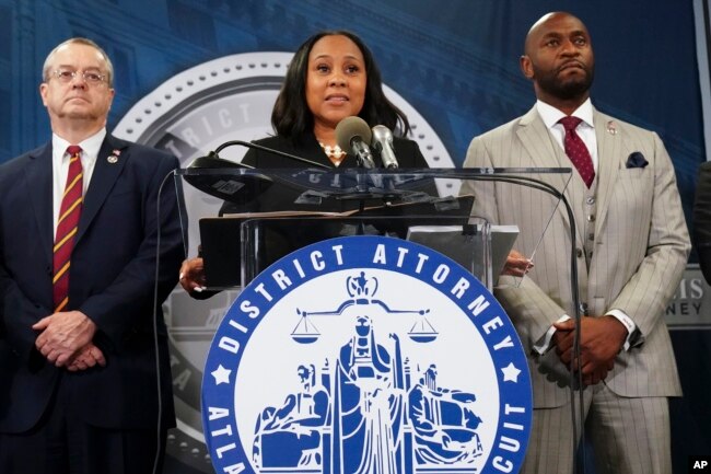 Fulton County District Attorney Fani Willis, center, speaks at the Fulton County Government Center during a news conference, in Atlanta, Georgia, Aug. 14, 2023. Donald Trump and several allies have been indicted in Georgia over efforts to overturn his 2020 election loss in the state. (AP Photo/John Bazemore)