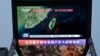 资料照片：北京街头巨幅电视屏幕播放中国军队东部战区绕台军演的新闻。 (2024年5月23日)