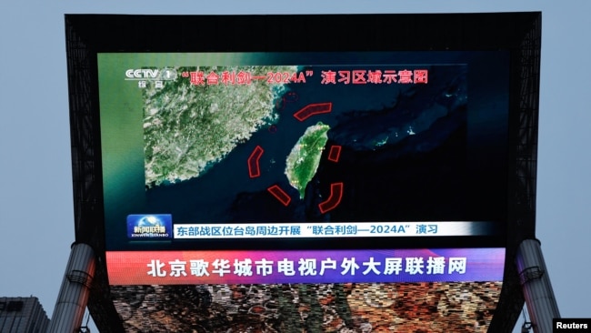 北京街头巨幅电视屏幕播放中国军队东部战区绕台军演的新闻. (2024年5月23日)