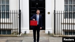 Britain's Chancellor of the Exchequer Jeremy Hunt holds the budget box on Downing Street in London, March 15, 2023. 