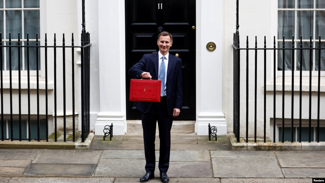 Menteri Keuangan Inggris Jeremy Hunt memegang kotak anggaran di Downing Street, London, Inggris, 15 Maret 2023. (REUTERS/Peter Nicholls)