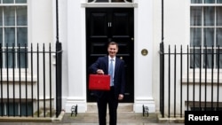 Britain's Chancellor of the Exchequer Jeremy Hunt holds the budget box on Downing Street in London, March 15, 2023. 