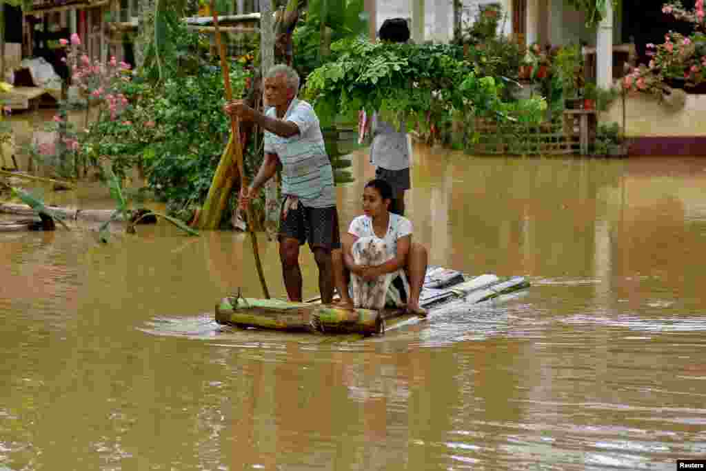 Flood-affected people use a makeshift raft to a safer place following heavy rains at the Patiapam village in Nagaon district, in the northeastern state of Assam, India.