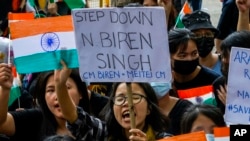 FILE — Members of the Kuki tribe protest the killing of tribals in their northeastern home state of Manipur, while they hold Indian flags and placards during a sit-in in New Delhi, India, May 29, 2023. 