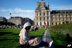 A woman sits at the Tuileries Garden, during the 2024 Summer Olympics, July 28, 2024, in Paris, France.