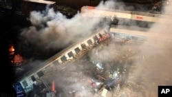 Smoke rises from trains as firefighters and rescuers operate after a collision near Larissa city, Greece, early March 1, 2023.