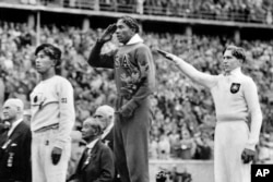 ARHIVA - Američki atletičar Džesi Ovens na pobedničkom postolju na Olimpijskim igrama u Berlinu 1936. (Foto: AP)