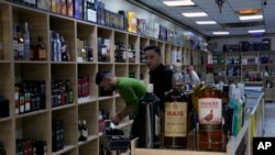 People buy alcohol in a liquor store in Baghdad, Iraq, March 9, 2023. The Iraqi government started enforcing a 2016 ban on alcoholic beverages this month, but religious minorities are pushing back against the measure.