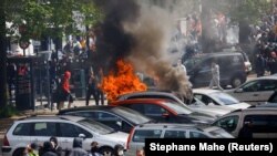 Učesnici protesta prolaze pored zapaljenih automobila u Nantu, u Francuskoj (Foto: REUTERS/Stephane Mahe)