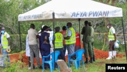 Forensic experts and homicide detectives from the Directorate of Criminal Investigations (DCI), gather to exhume bodies of suspected followers of a Christian cult named as 'Good News International Church', in Shakahola forest, Kenya, May 9, 2023.