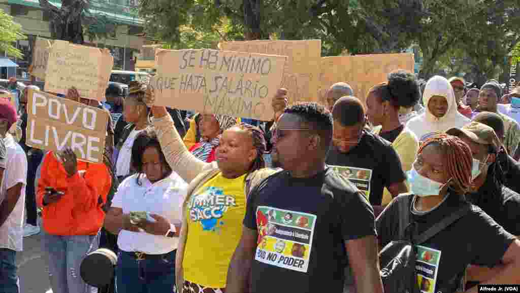 Manifestante exibe cartaz dizendo "Se há mínimo que haja salário máximo", durante marcha em Maputo pela democracia e melhores condições de vida. 24 junho 2023