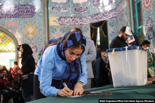 An Iranian woman votes at a polling station in Tehran, Iran, during a snap presidential election to choose a successor to Ebrahim Raisi following his death in a helicopter crash, June 28, 2024. (Majid Asgaripour/West Asia News Agency via Reuters)