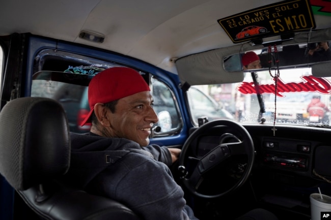 Taxi driver Claudio Garcia sits inside his Volkswagen Beetle he has named "Gualupita" after his wife, in the Cuautepec neighborhood of Mexico City, Friday, June 21, 2024. (AP Photo/Aurea Del Rosario)