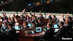 Anggota parlemen memberikan suara saat pembacaan kedua RUU Perlindungan Keamanan Nasional, di Dewan Legislatif Hong Kong, di Hong Kong, China, 19 Maret 2024. (Foto: Joyce Zhou/Reuters)