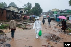 Residents walk in a street in Blantyre on March 14, 2023, following heavy rains after Cyclone Freddy made landfall.