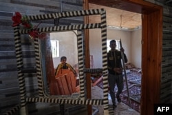 Palestinians inspect their damaged house in Rafah in the southern Gaza Strip, on May 14, 2023.