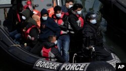FILE - People thought to be migrants picked up by a British Border Force vessel as they attempted to cross the Channel from France to Britain, are delivered to the port in Dover, southeast England, June 17, 2022.