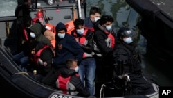 FILE - People thought to be migrants picked up by a British Border Force vessel as they attempted to cross the Channel from France to Britain, are delivered to the port in Dover, southeast England, June 17, 2022.