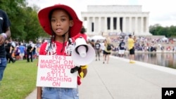 T'Kyrra Terrell, 6, poses for a portrait on her way to the 60th Anniversary of the March on Washington at the Lincoln Memorial in Washington, Aug. 26, 2023.