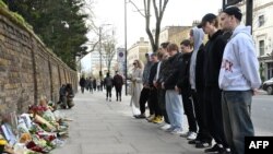 People pay their respects after laying flowers outside the Russian embassy in London on March 23, 2024, a day after a gun attack in Krasnogorsk, outside Moscow.