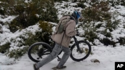 A man pushes his BMX bike up the canyon at the Deukmejian Wilderness Park, a rugged 709-acre site in the foothills of the San Gabriel Mountains, at the northernmost extremity of the City of Glendale, California, Feb. 26, 2023. 